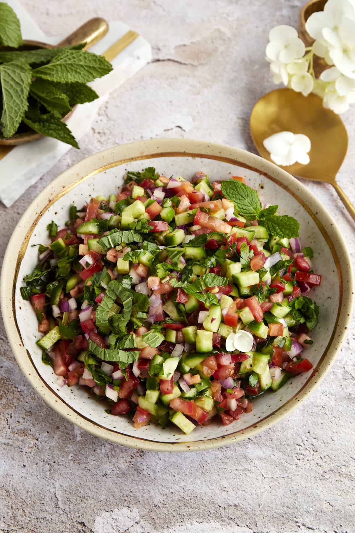 A bowl of finely chopped Persian salad with mint and herbs, seen from above